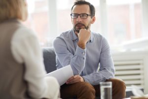 therapist explaining to worried man what is the difference between addiction and dependence
