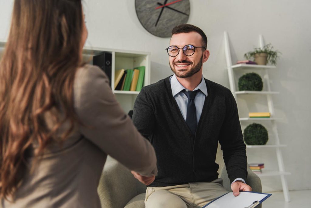 smiling patient and therapist discussing what is an aftercare program in an office setting