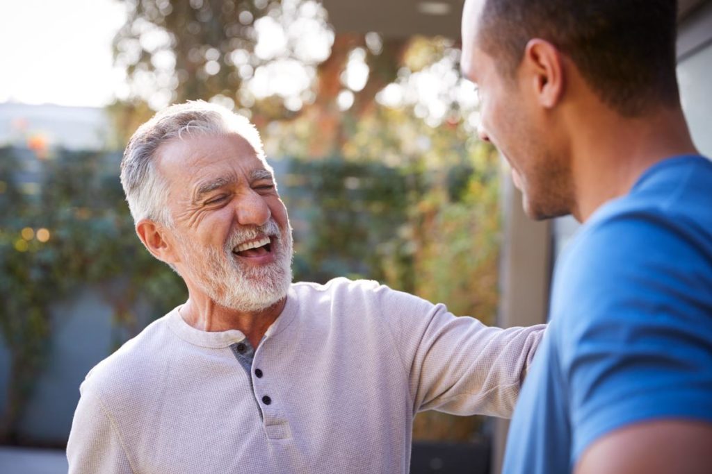 older man greeting younger man outside on a beautiful spring day while struggling with ow to stay sober in spring
