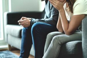 Hands of a couple discussion the link between addiction and infidelity