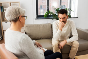 young man discussing bipolar disorder treatment with female therapist in an office setting