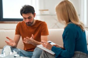 young man talking seriously with female therapist about entering a meth rehab program