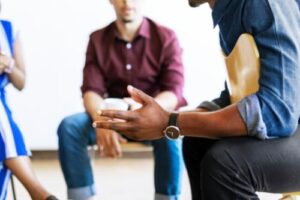 group of young men and women sitting in a group as part of an opioid rehab program