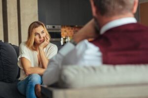 young woman listening intently to therapist as he describes the benefits of an outpatient program