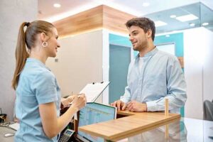 young man being admitted to day treatment program by female behavioral health professional