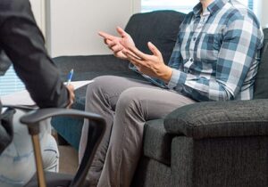 Young man explaining to behavioral health therapist why he needs an anxiety treatment program