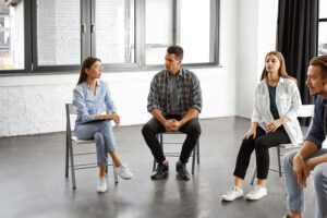 group of young men and women in a group session as part of an ecstasy abuse rehab program