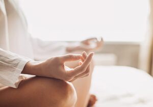 close up of a person's lap as they sit in lotus position as part of a meditative therapy program