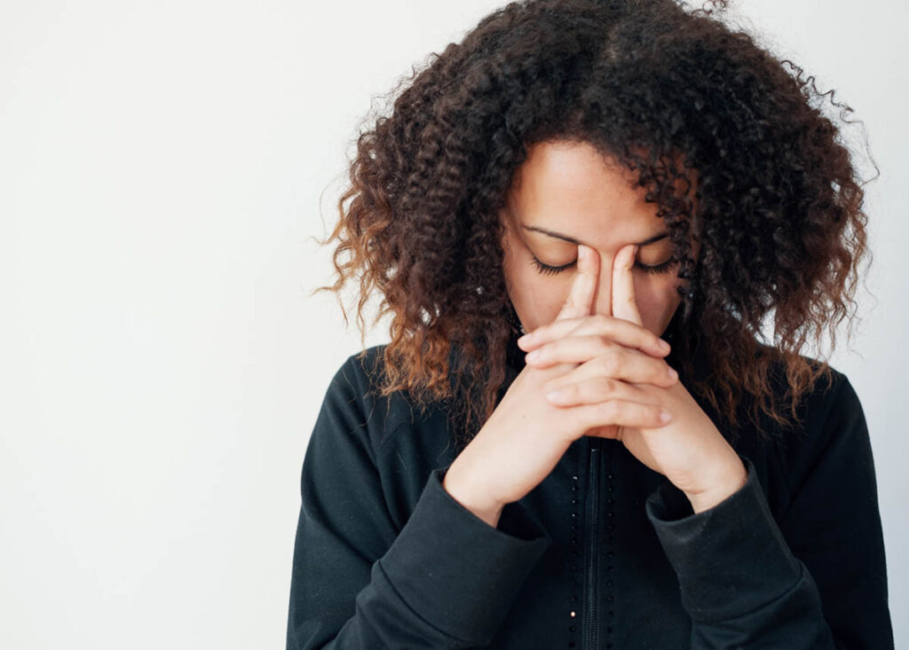 a person with a headache holds their face as they deal with tramadol side effects