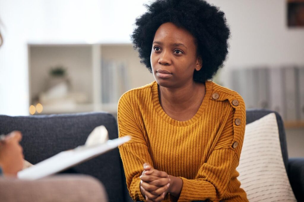 young woman meeting with her addiction counselor to discuss how addiction can worsen anxiety.