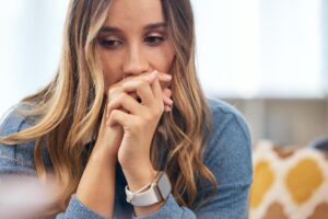 distraught young woman clenches her hands together as she ponders Xanax side effects