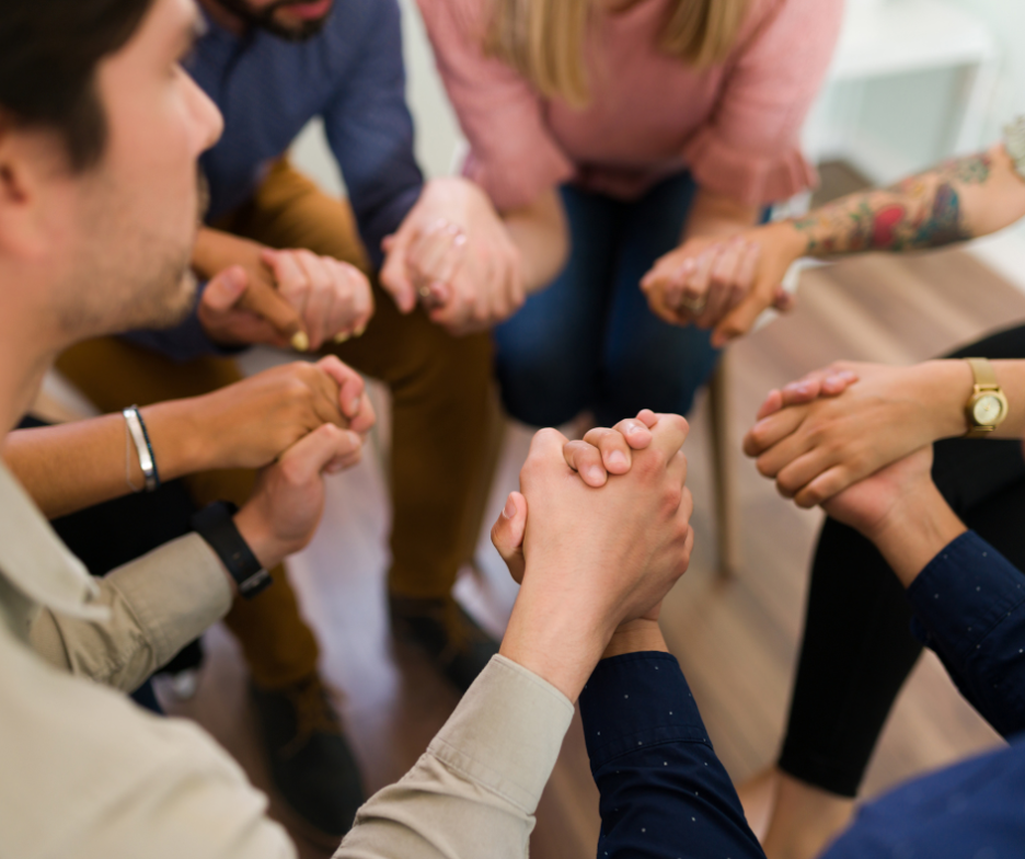 People in AA hold hands as they learn about the doctor's opinion